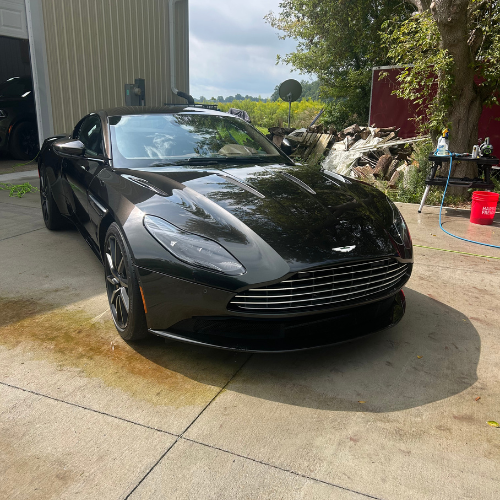 Black Aston Martin DB11 detailed and glossy in a driveway