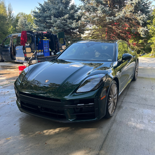 Green Porsche Panamera detailed beside the mobile detailing van