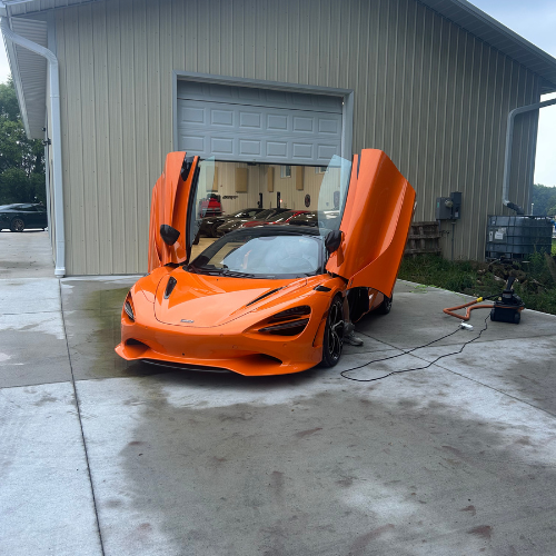 Orange McLaren 750S front three-quarter view after a full detail