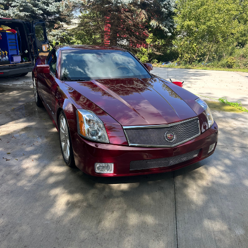 Red Cadillac XLR-V polished in a driveway