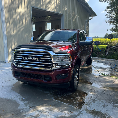 Red Ram 2500 Longhorn freshly washed outside a pole barn